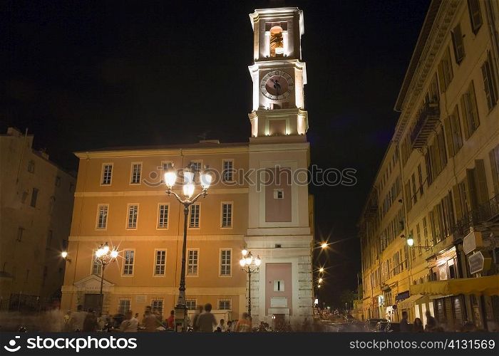 Low angle view of a clock tower lit up at night, Nice, France