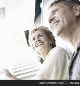 Low angle view of a couple standing on the staircase of a cruise ship and smiling