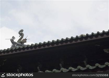 Low angle view of a dragon sculpture on the roof of a temple