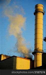 Low angle view of a factory smoke stack emitting smoke, Boston, Massachusetts, USA