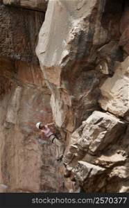 Low angle view of a female rock climber scaling a rock face