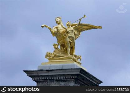 Low angle view of a gilded statue, La Renommee Au Combat, Pont Alexandre III, Paris, France