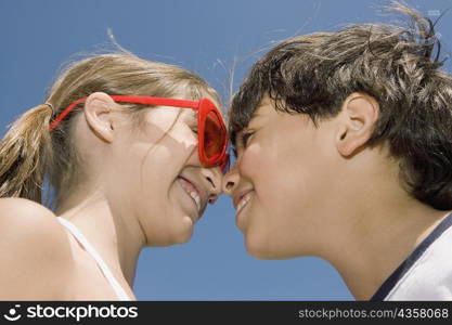 Low angle view of a girl and her brother looking at each other and smiling