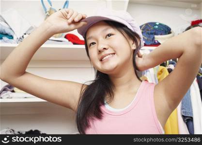 Low angle view of a girl holding a cap smiling