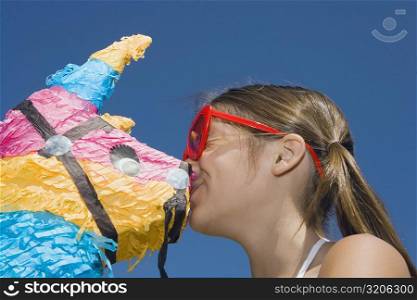 Low angle view of a girl kissing a rocking horse