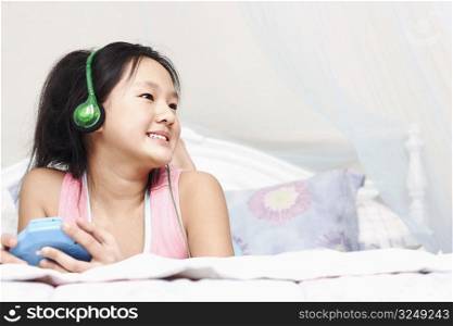 Low angle view of a girl listening to music on an MP3 player