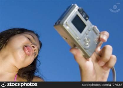 Low angle view of a girl taking a photograph of herself