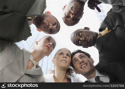 Low angle view of a group of business executives in huddle