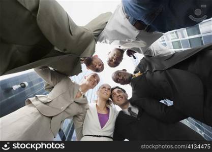 Low angle view of a group of business executives standing in huddle
