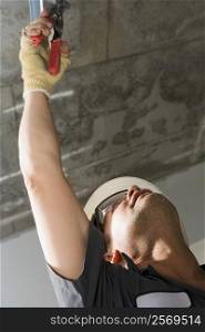 Low angle view of a male construction worker working with pliers