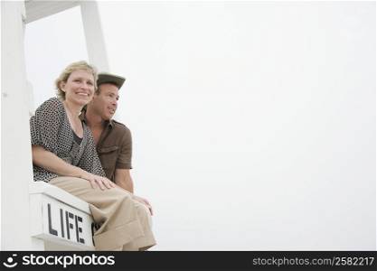 Low angle view of a mature couple sitting in a lifeguard hut