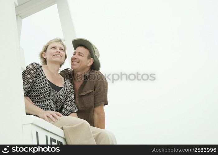 Low angle view of a mature couple sitting in a lifeguard hut