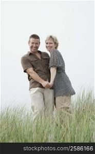 Low angle view of a mature couple standing in a grassy field