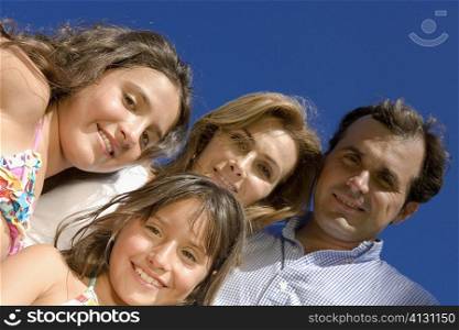 Low angle view of a mature couple standing with their two daughters and smiling