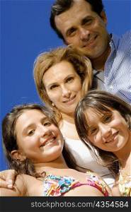 Low angle view of a mature couple standing with their two daughters and smiling