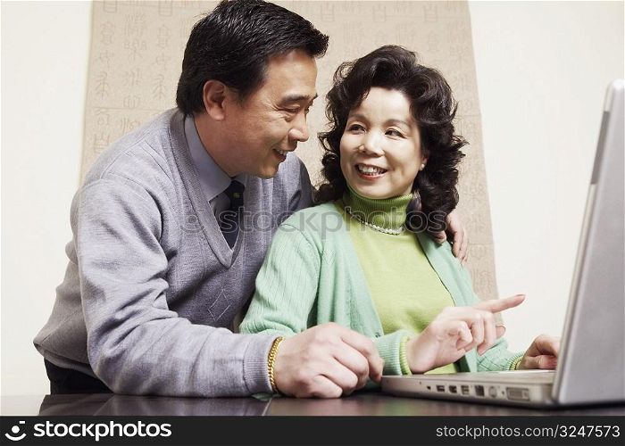 Low angle view of a mature couple using a laptop
