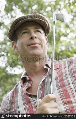 Low angle view of a mature man holding a golf club