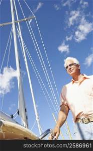 Low angle view of a mature man standing in a sailboat
