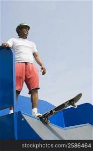 Low angle view of a mature man standing on a skateboard ramp