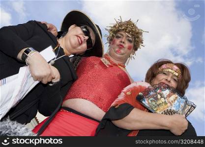 Low angle view of a mature man with two mature women wearing costumes