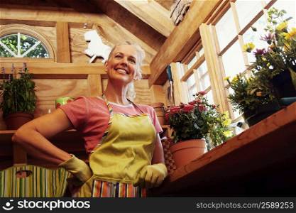 Low angle view of a mature woman standing near potted plants
