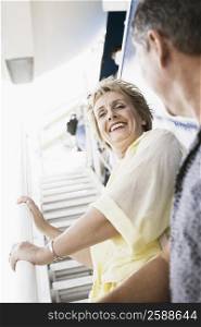 Low angle view of a mature woman standing on the staircase of a cruise ship and smiling