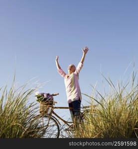 Low angle view of a mature woman standing with her arms raised