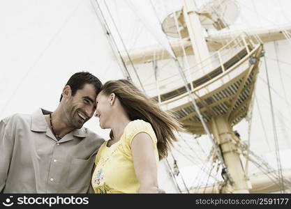 Low angle view of a mid adult couple on a sailing ship and smiling