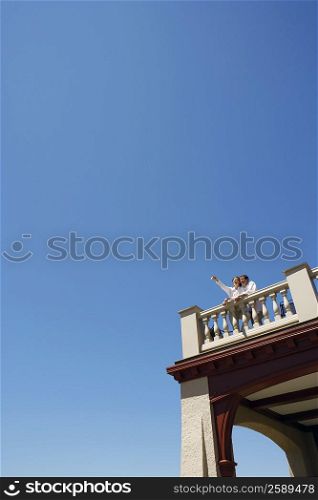 Low angle view of a mid adult couple standing on the roof of a building
