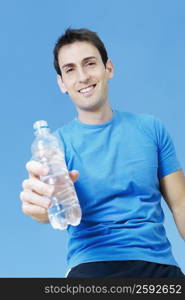 Low angle view of a mid adult man holding a water bottle