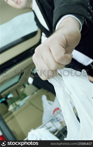 Low angle view of a mid adult man holding shopping bags