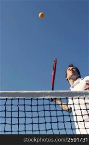 Low angle view of a mid adult man playing tennis