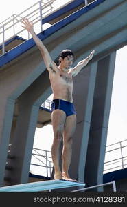 Low angle view of a mid adult man taking start from a diving platform