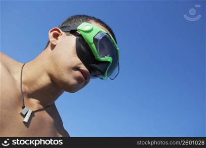 Low angle view of a mid adult man wearing swimming goggles
