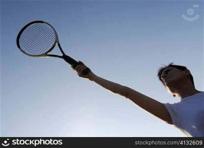 Low angle view of a mid adult woman holding a tennis racket