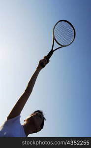 Low angle view of a mid adult woman holding a tennis racket