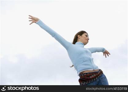 Low angle view of a mid adult woman with her arms outstretched