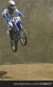Low angle view of a motocross rider performing a jump on a motorcycle