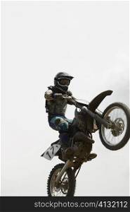 Low angle view of a motocross rider performing a jump on a motorcycle