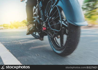 Low angle view of a motorcyclist riding motorcycle. Close up of motorcyclist feet on his motorbike. Low angle view of a biker driving his motorbike