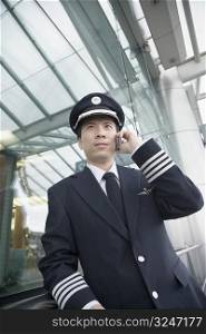 Low angle view of a pilot talking on a mobile phone