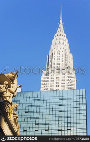 Low angle view of a sculpture in font of a skyscraper, Empire State Building, New York City, New York State, USA