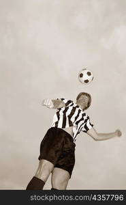 Low angle view of a soccer player heading a soccer ball