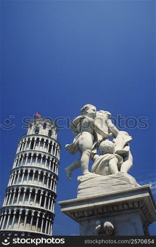 Low angle view of a statue in front of a tower, Leaning Tower of Pisa, Pisa, Tuscany, Italy