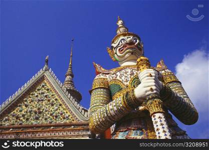 Low angle view of a statue of demon in front of a temple, Wat Arun, Bangkok, Thailand