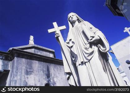 Low angle view of a statue of Virgin Mary with a cross
