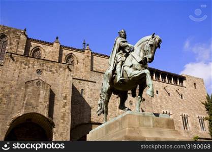 Low angle view of a statue on a pedestal in front of a building, Barcelona, Spain