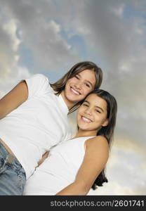 Low angle view of a teenage girl standing with her sister