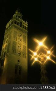 Low angle view of a tower lit up at night, La Giralda, Seville, Andalusia, Spain