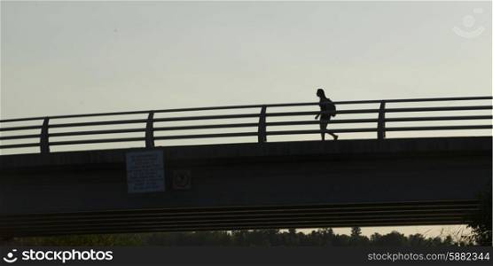 Low angle view of a woman walking on bridge, Kenora, Lake of the Woods, Ontario, Canada